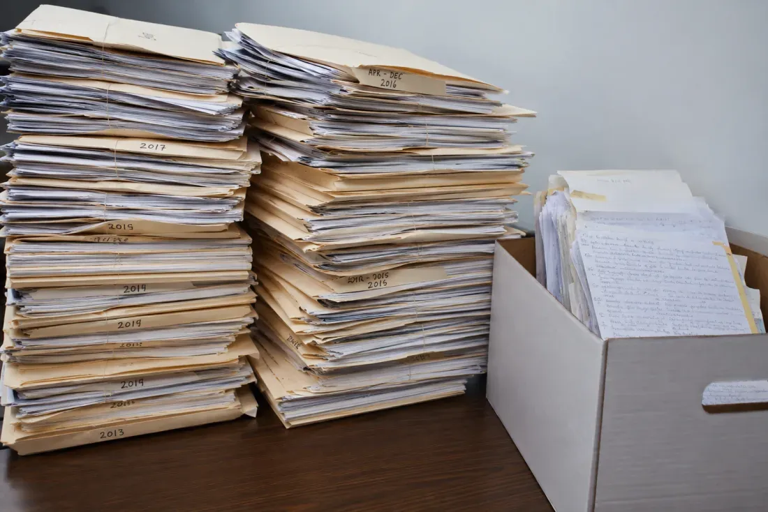 A large backlog of handwritten legal documents to be processed